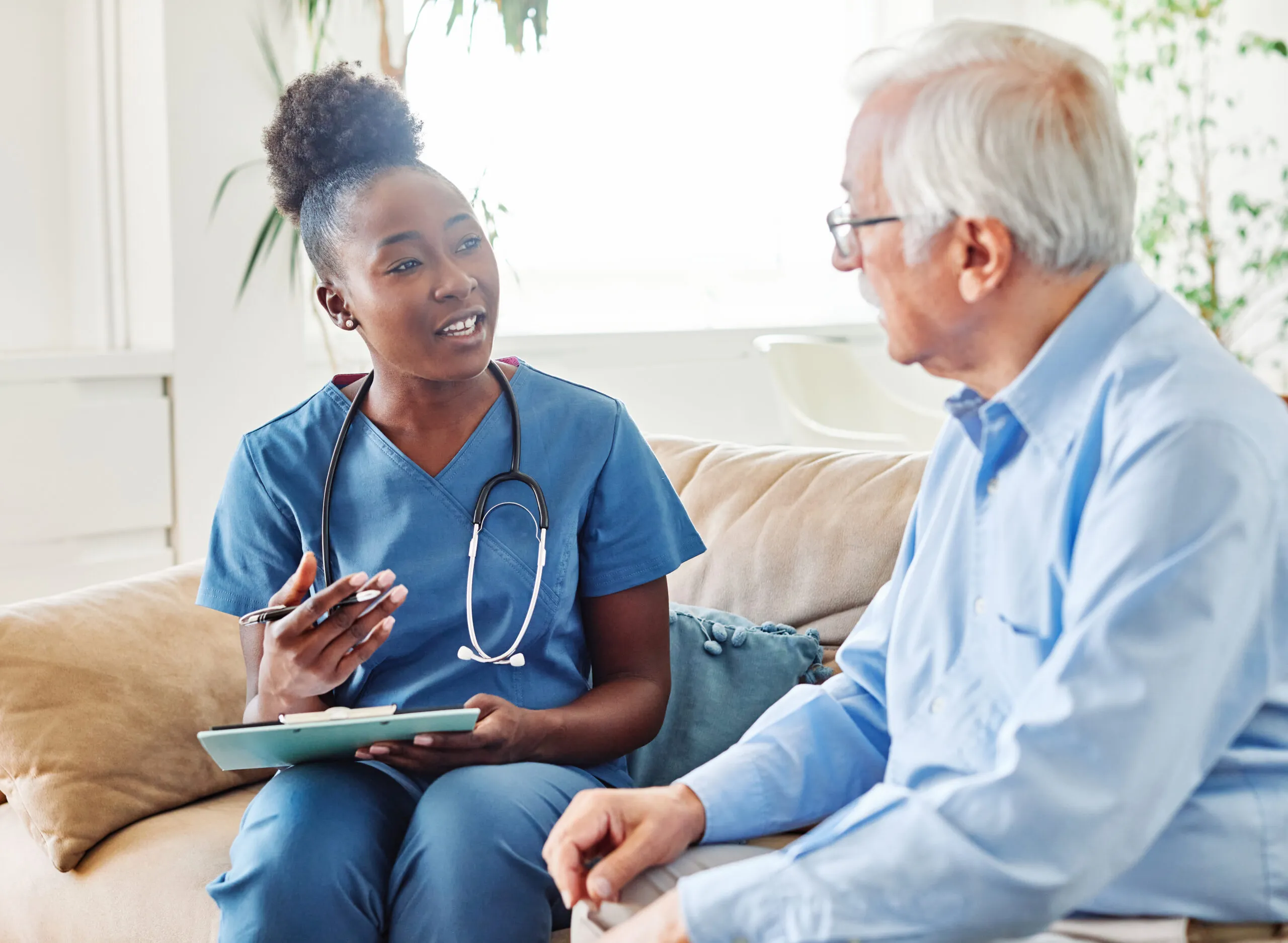 nurse senior woman home care patient elderly health retirement c Home caregiver assisting elderly person in Schoenchen, KS, with daily tasks and providing companionship.